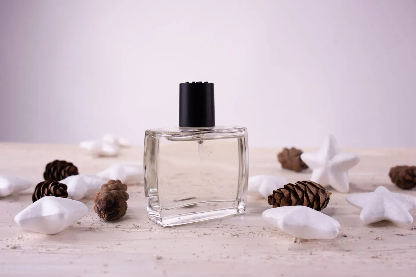 Flacon de parfum et pommes de pin